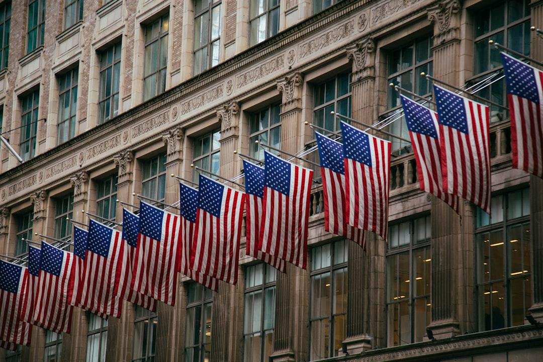 American flags hang in a row on a building.