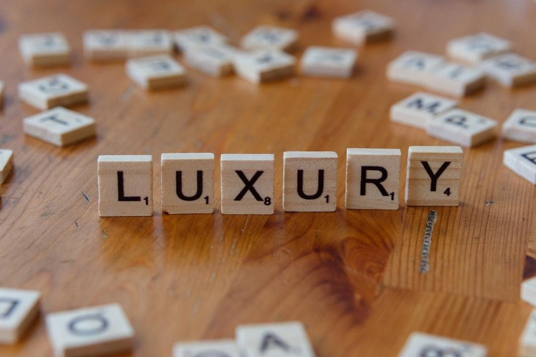 Scrabble tiles spelling the word luxury on a wooden table
