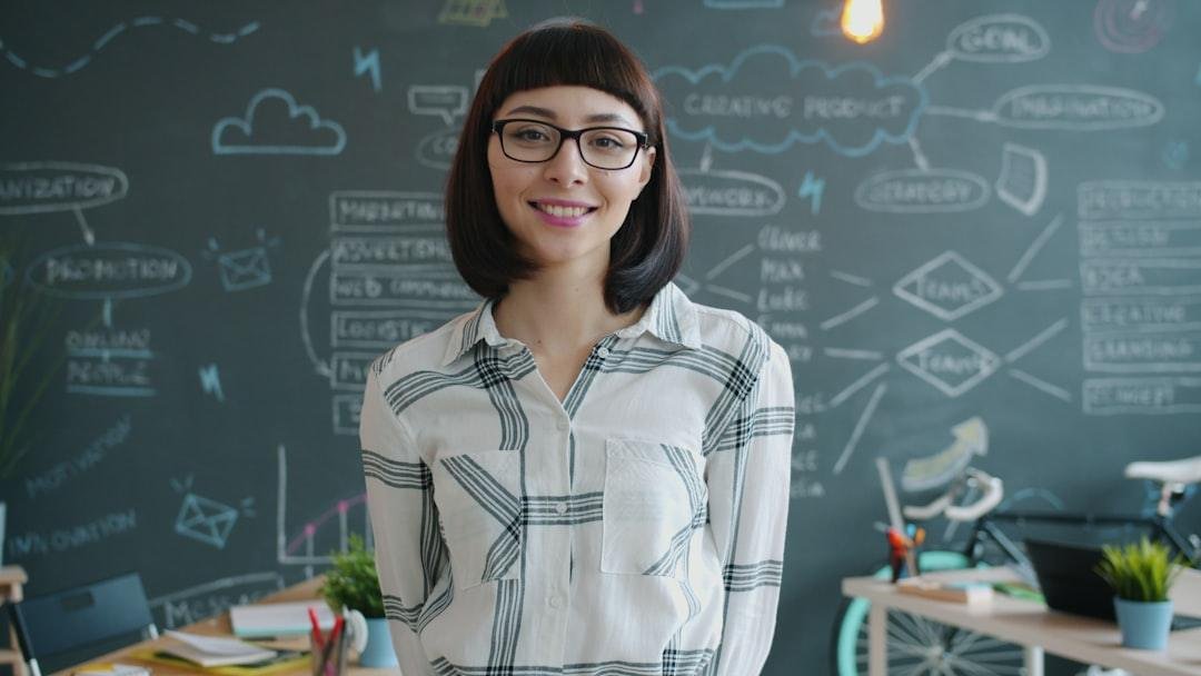 Young woman smiling in front of a chalkboard